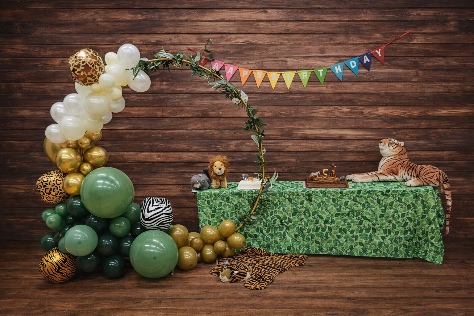 Jungle safari first birthday with sage and gold hoop arch and animal-print accents